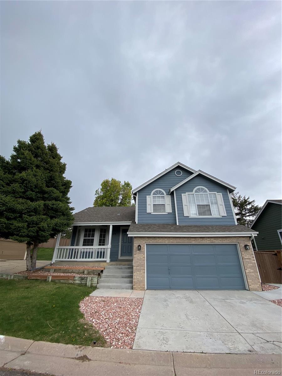 874 Homestead Drive Highlands Ranch, CO 80126 - Photo 1 of 13 a front view of a house with a yard and garage