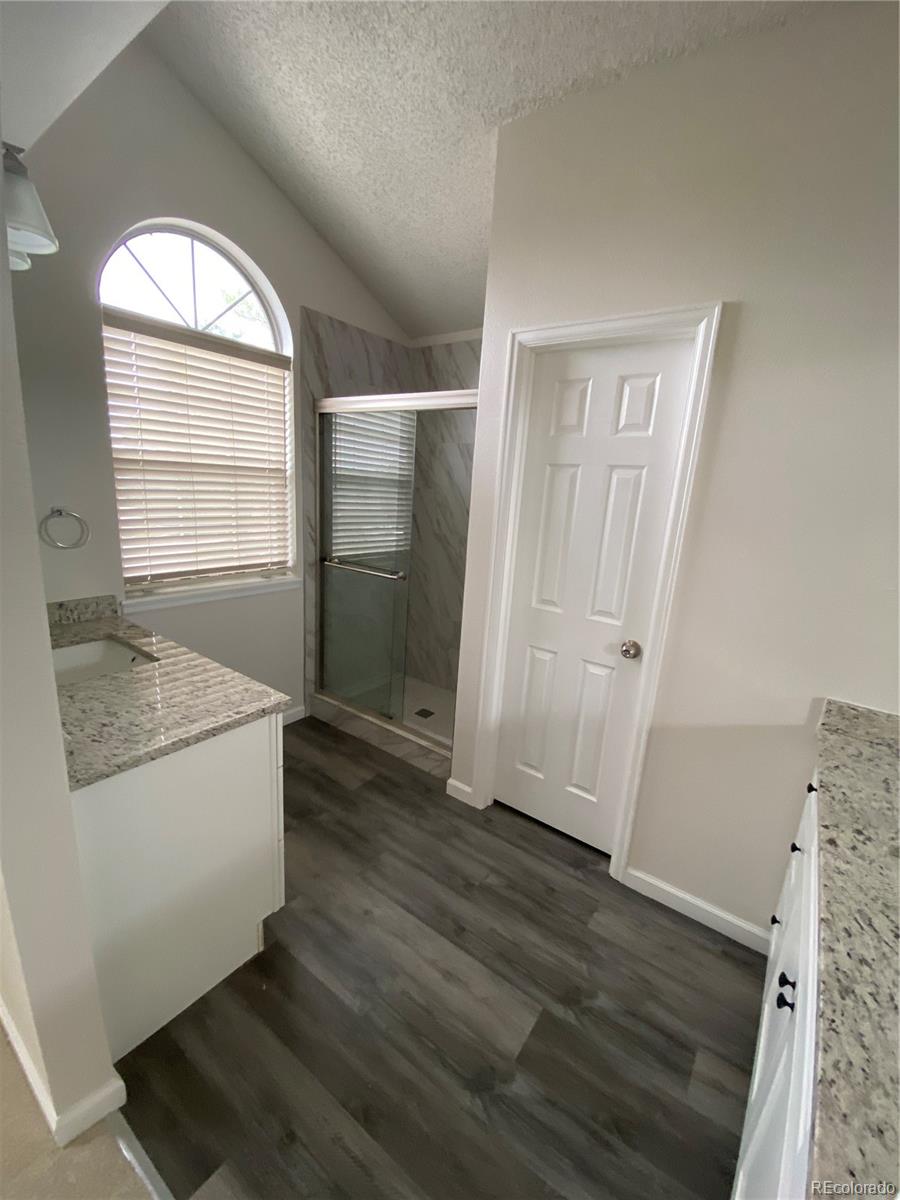 874 Homestead Drive Highlands Ranch, CO 80126 - Photo 10 of 13 an empty room with wooden floor cabinet and windows