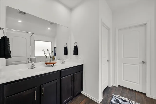 a bathroom with a double vanity sink and mirror