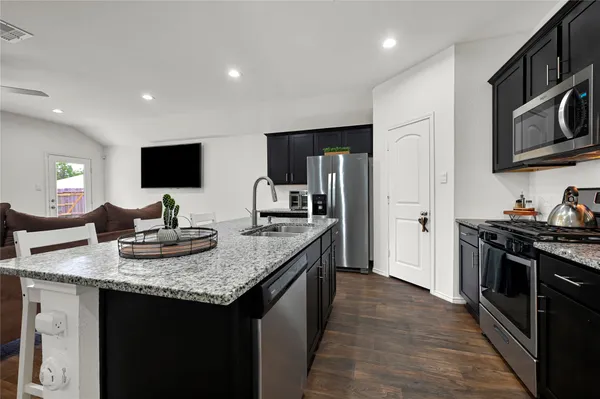 a kitchen with stainless steel appliances granite countertop a sink stove and refrigerator
