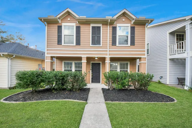 a front view of a house with garden and plants
