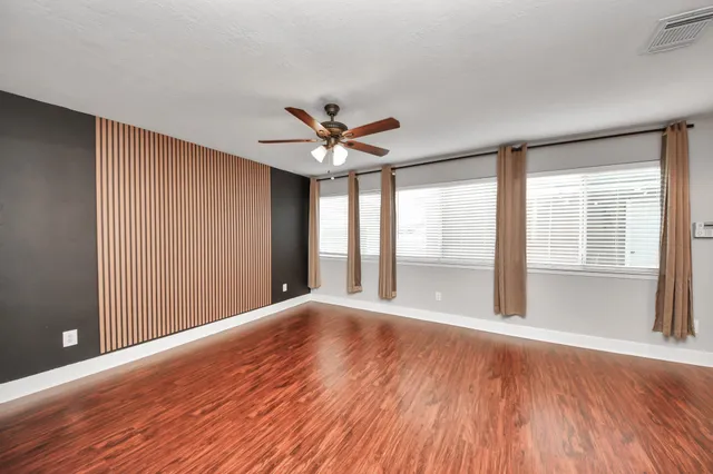 a large white kitchen with kitchen island a stove a sink dishwasher and white cabinets with wooden floor