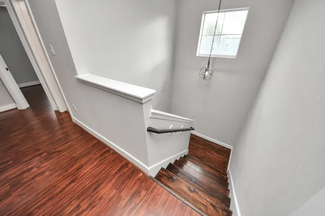 a view of an empty room with wooden floor