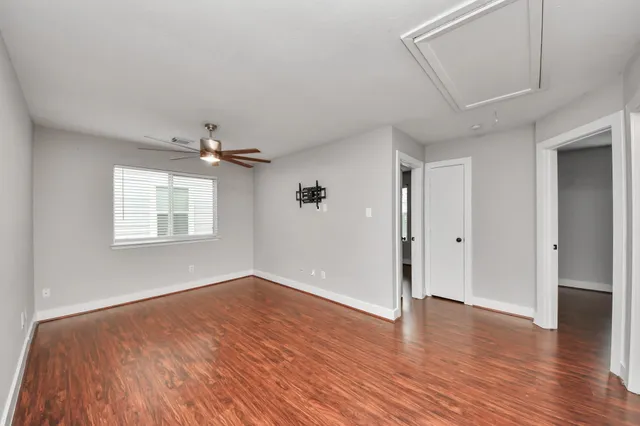 a view of an empty room with wooden floor and closet