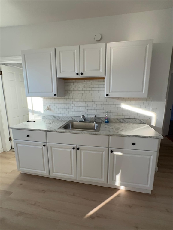 11 Alpine Street, Unit 3 Worcester, MA 01610 - Photo 4 of 14 a kitchen with granite countertop white cabinets white appliances and a sink