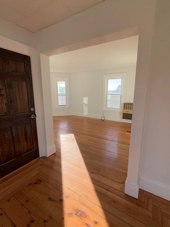 11 Alpine Street, Unit 3 Worcester, MA 01610 - Photo 6 of 14 a view of an empty room with wooden floor and a window