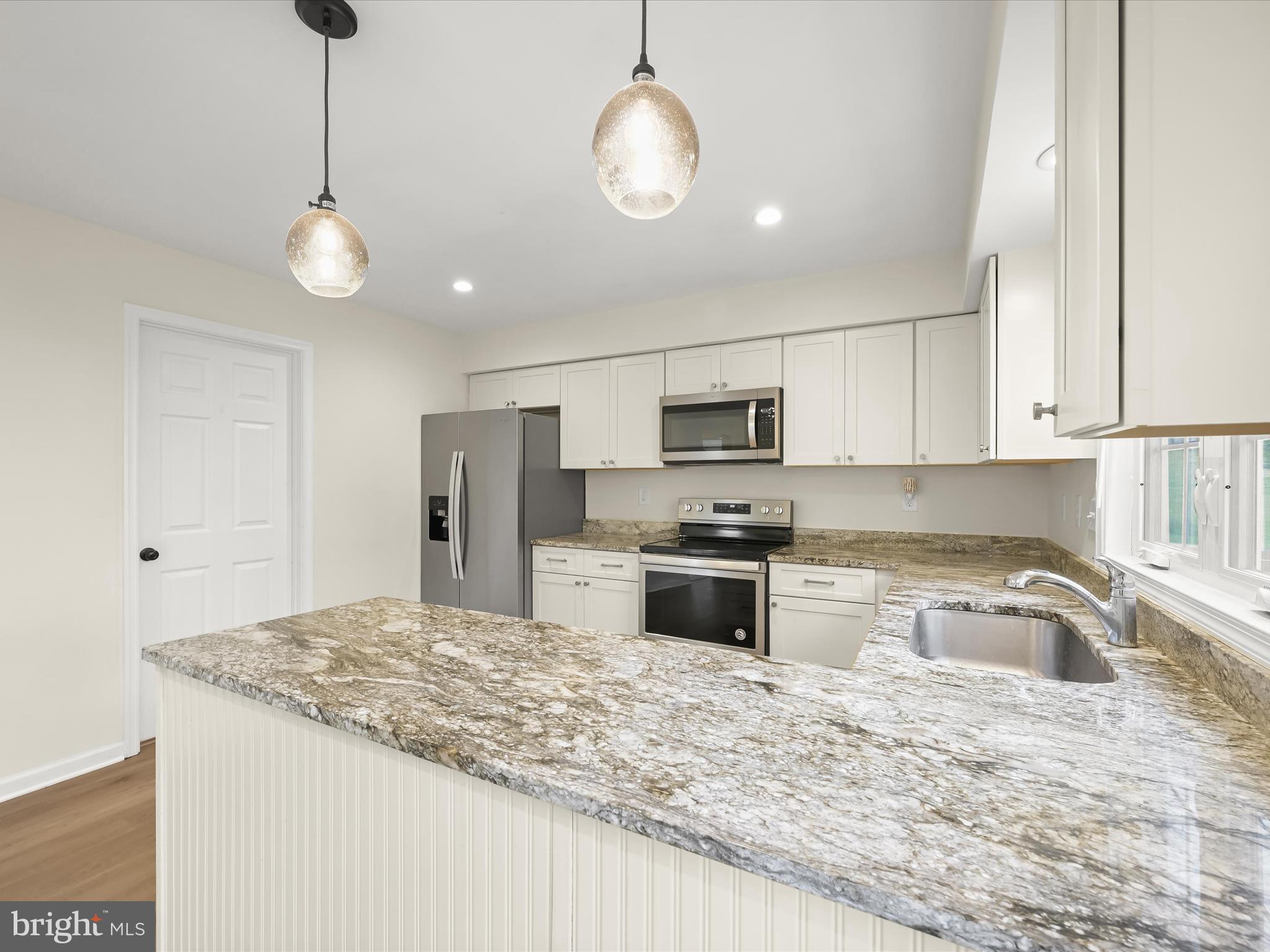 8806 Admiral Drive Laurel, MD 20708 - Photo 16 of 59 a kitchen with stainless steel appliances granite countertop a sink refrigerator and microwave