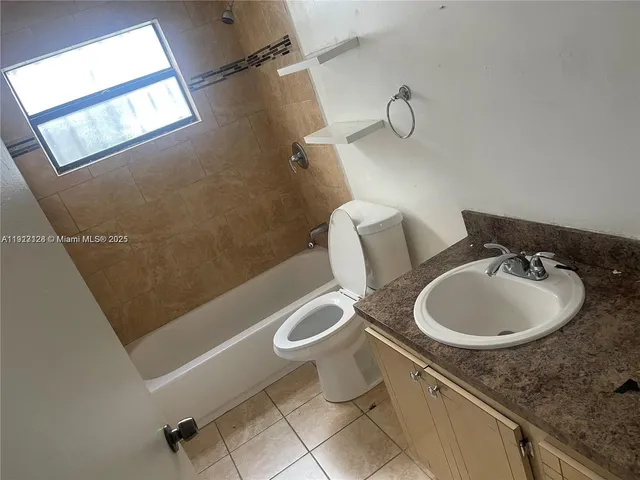 a bathroom with a granite countertop sink a toilet a mirror and shower