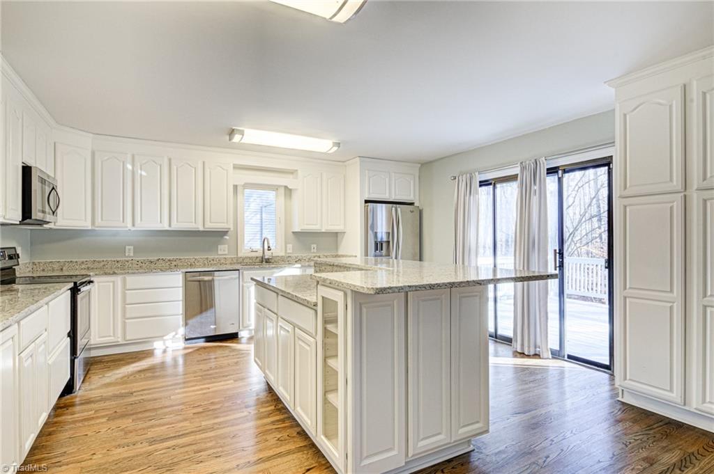 5101 Tower Road Greensboro, NC 27410 - Photo 3 of 36 Bright kitchen with pantry cabinets on right wall