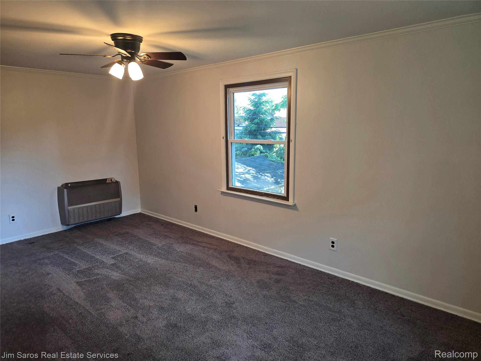 1762 Bournemouth Road Grosse Pointe, MI 48236 - Photo 15 of 21 Room featuring neutral wall paint, dark carpet flooring, a ceiling fan with integrated lighting, and a wall-mounted heating unit