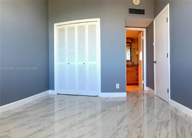 an empty room with wooden floor and closet