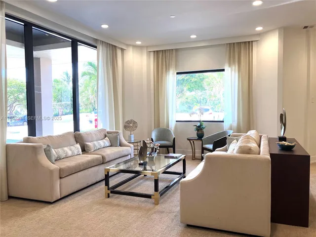 a living room with furniture and large windows