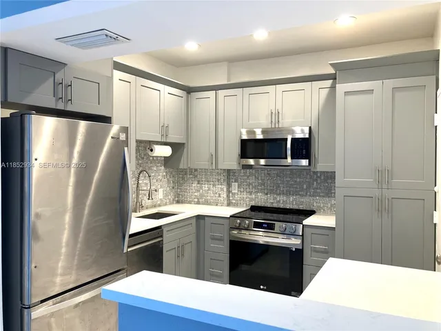 a kitchen with stainless steel appliances granite countertop a refrigerator stove and sink