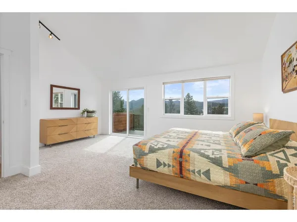 a bedroom with a bed next to a window