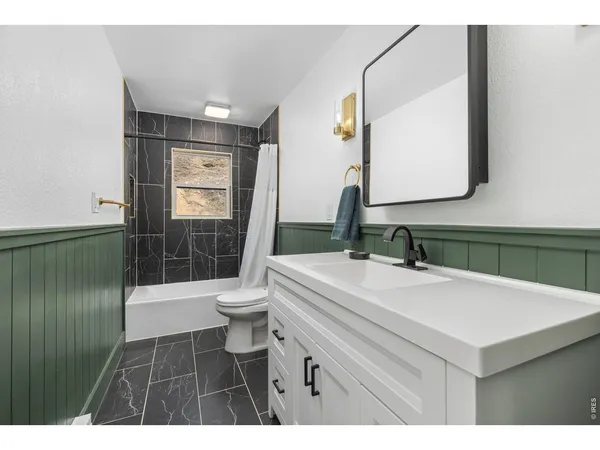 a bathroom with a sink a toilet a mirror and shower