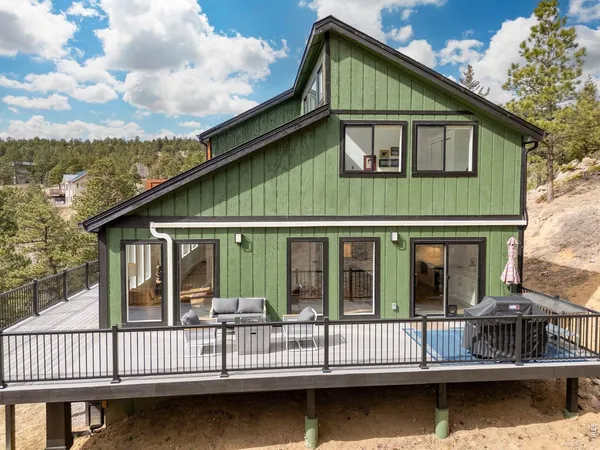 a view of small house with wooden deck