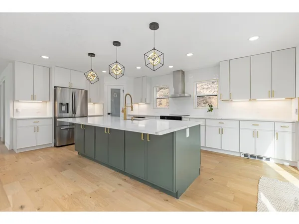 a kitchen with kitchen island granite countertop a sink cabinets and stainless steel appliances