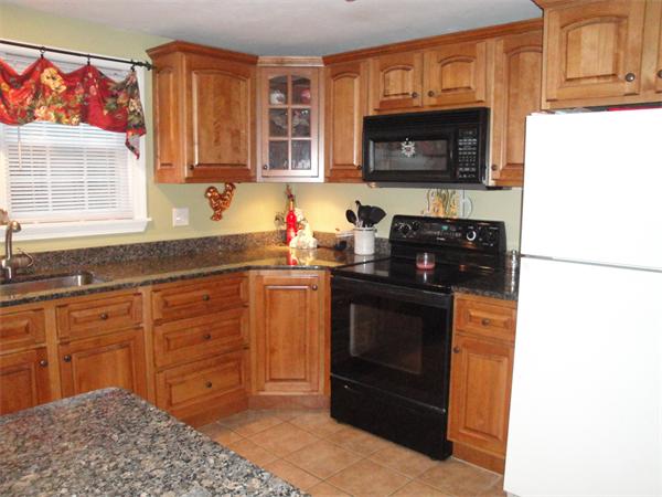 82 Campground Road Sterling, MA 01564 - Photo 5 of 23 a kitchen with granite countertop a stove top oven microwave and cabinets