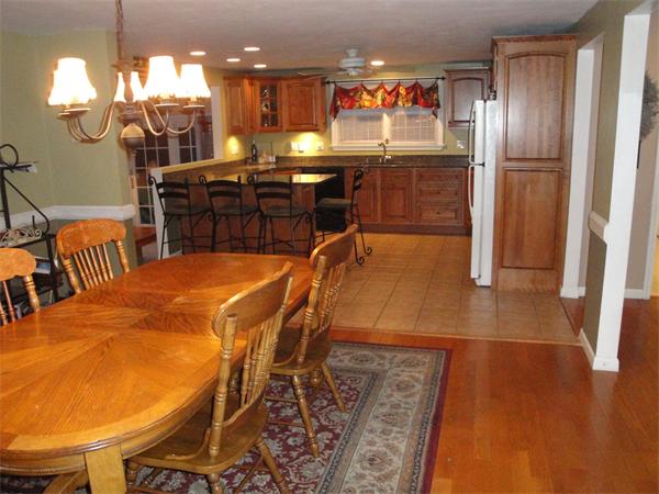 82 Campground Road Sterling, MA 01564 - Photo 8 of 23 a kitchen with stainless steel appliances kitchen island granite countertop a refrigerator a stove a dining table and chairs with wooden floor