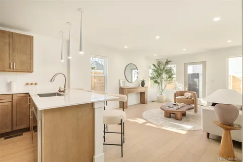 a living room with furniture a large window and a sink