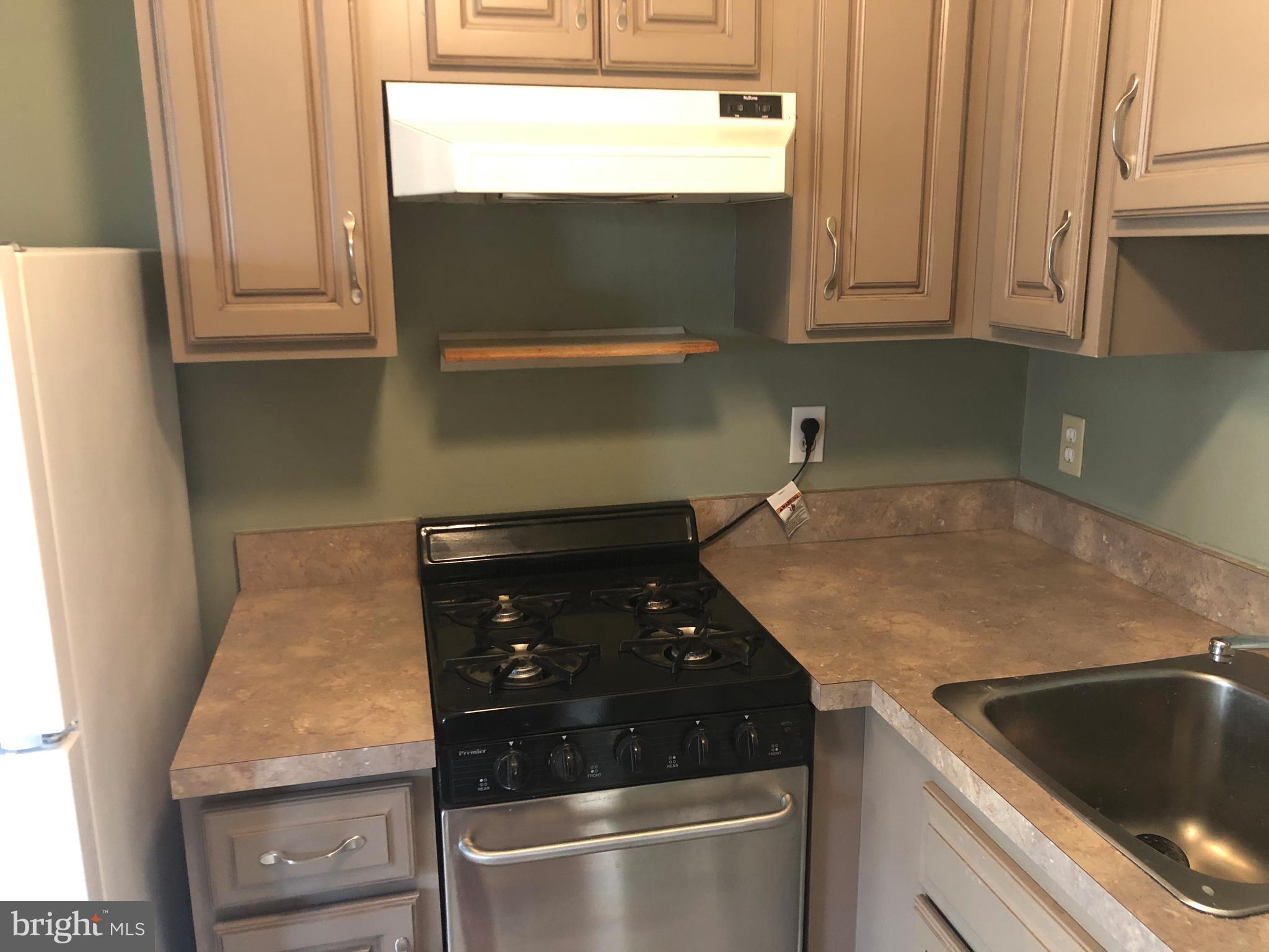 519 Epsom Road, Unit 1C Baltimore, MD 21286 - Photo 29 of 54 a kitchen with granite countertop white cabinets and a stove