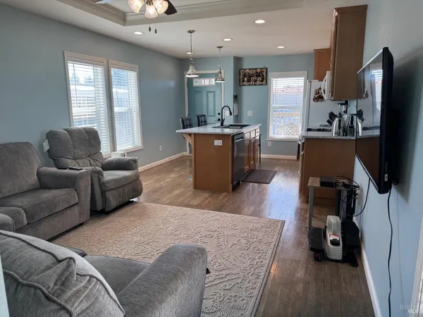 a living room with furniture a flat screen tv and a large window