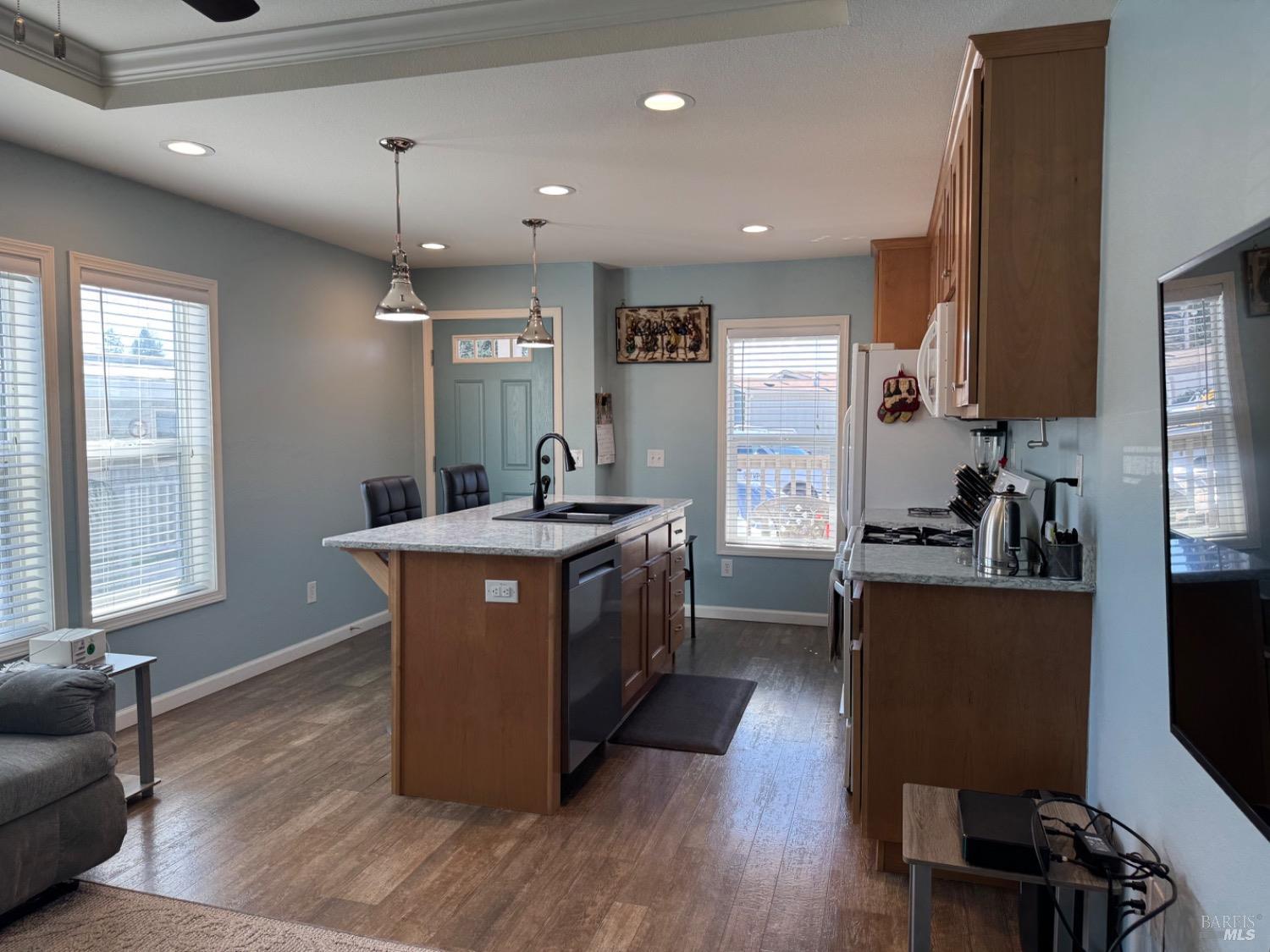62 Romani Court Santa Rosa, CA 95407 - Photo 13 of 32 a kitchen with kitchen island granite countertop wooden floors and white cabinets