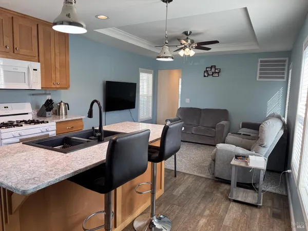 a living room with furniture a chandelier and a flat screen tv