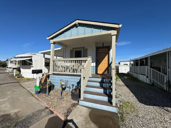 a front view of a house with wooden deck stairs