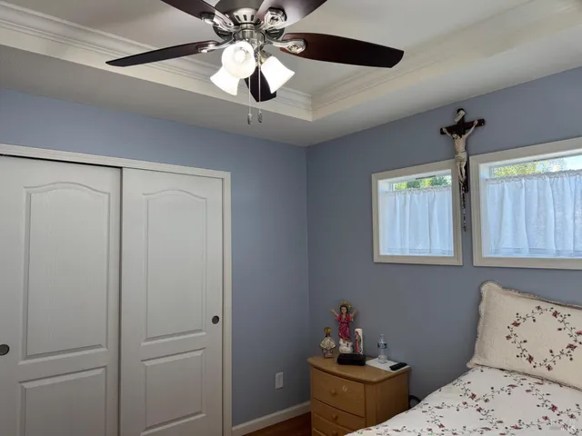 a bedroom with a bed and a chandelier fan