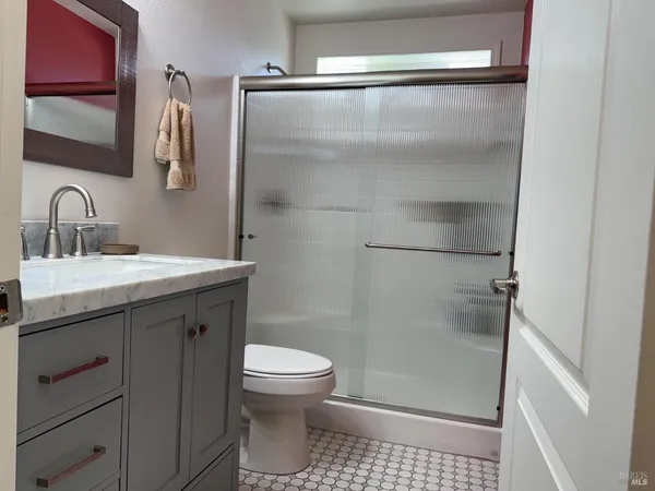 a bathroom with a sink a toilet and shower