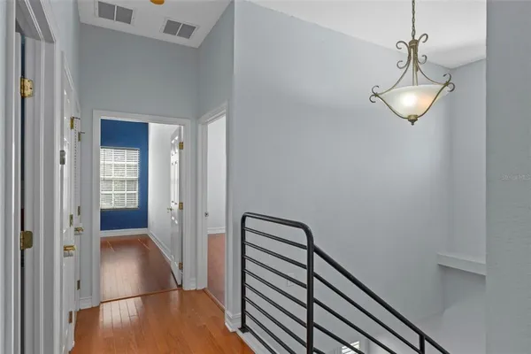 a view of a hallway with wooden floor and staircase