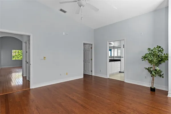 a view of an empty room with wooden floor and a window