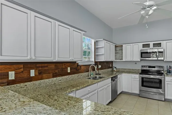 a kitchen with granite countertop a sink stainless steel appliances and cabinets