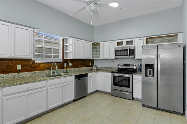 a kitchen with stainless steel appliances granite countertop a stove sink and microwave