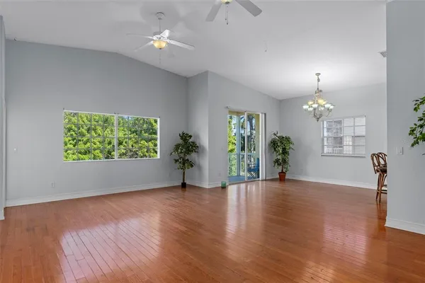 a view of an empty room with window and wooden floor