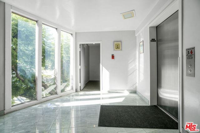 a view of a hallway with wooden floor and dining room