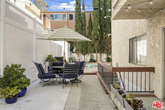 a view of a patio with table and chairs and potted plants