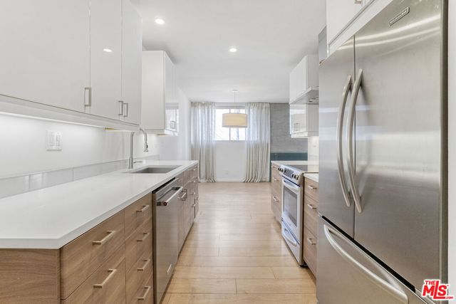 a kitchen with granite countertop a refrigerator and a sink