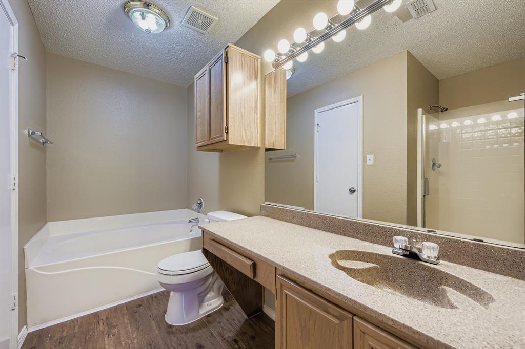 3326 Spring Meadow Lane Grand Prairie, TX 75052 - Photo 12 of 22 a bathroom with a granite countertop bathtub sink vanity mirror and toilet