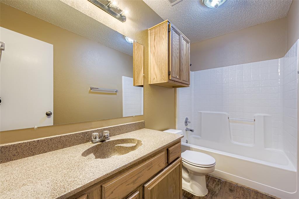 3326 Spring Meadow Lane Grand Prairie, TX 75052 - Photo 17 of 22 a bathroom with a granite countertop sink toilet and a mirror