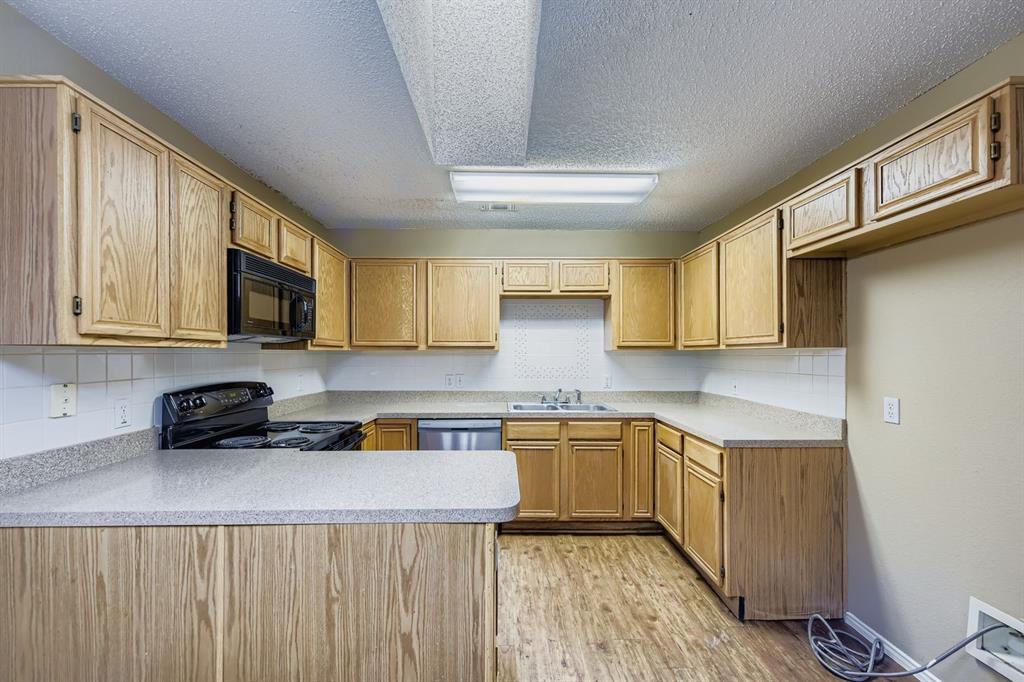 3326 Spring Meadow Lane Grand Prairie, TX 75052 - Photo 6 of 22 a kitchen with a sink a stove cabinets and a dining table