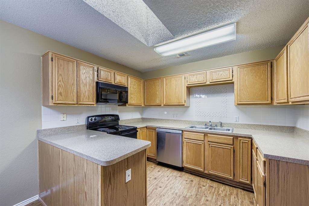 3326 Spring Meadow Lane Grand Prairie, TX 75052 - Photo 7 of 22 a kitchen with a sink a stove cabinets and a window