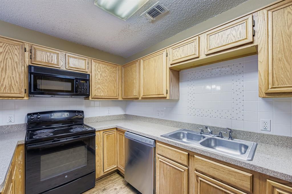 3326 Spring Meadow Lane Grand Prairie, TX 75052 - Photo 8 of 22 a kitchen with stainless steel appliances granite countertop a sink stove and microwave