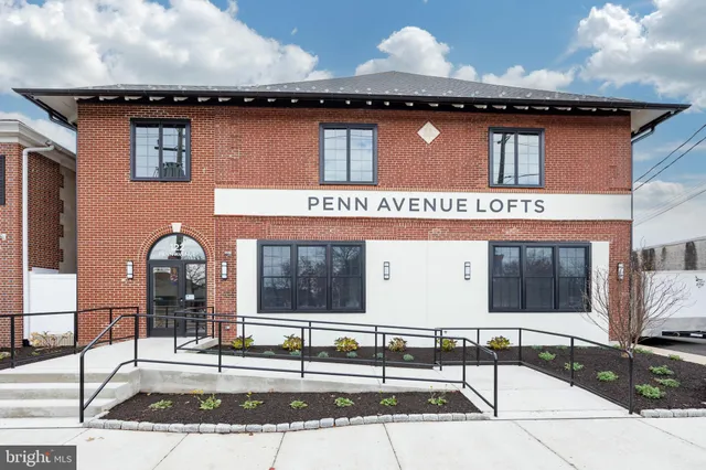 an aerial view of residential houses with outdoor space and parking