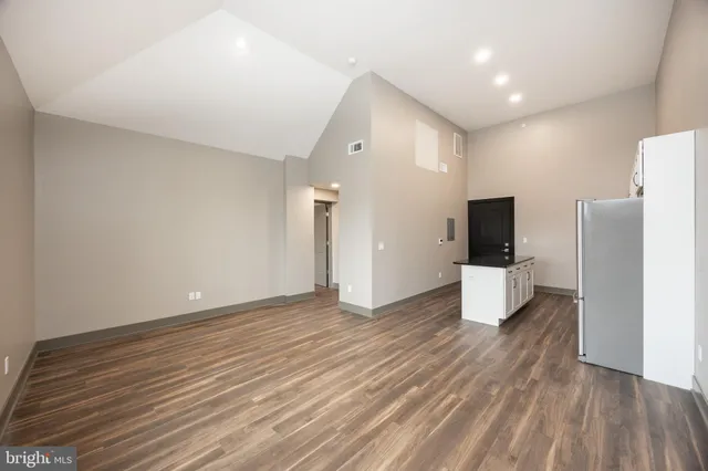 a kitchen with stainless steel appliances granite countertop a stove a sink and a refrigerator with wooden floor