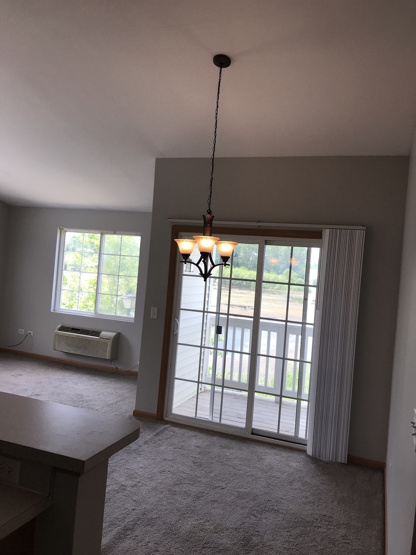 1131 Silverstone Drive, Unit 1131 Carpentersville, IL 60110 - Photo 13 of 23 a view of a room with furniture wooden floor and a window
