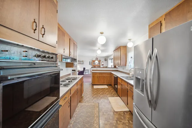 a kitchen with stainless steel appliances a stove a sink and a refrigerator