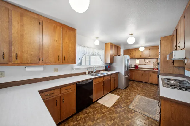 a kitchen with stainless steel appliances granite countertop a sink counter space cabinets and a large window