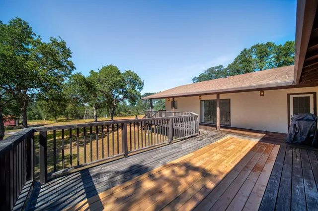 a view of a house with wooden deck and furniture